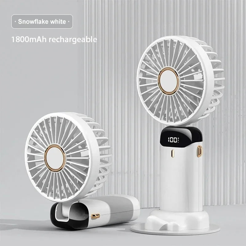 Portable neck fan in pink color standing on desk